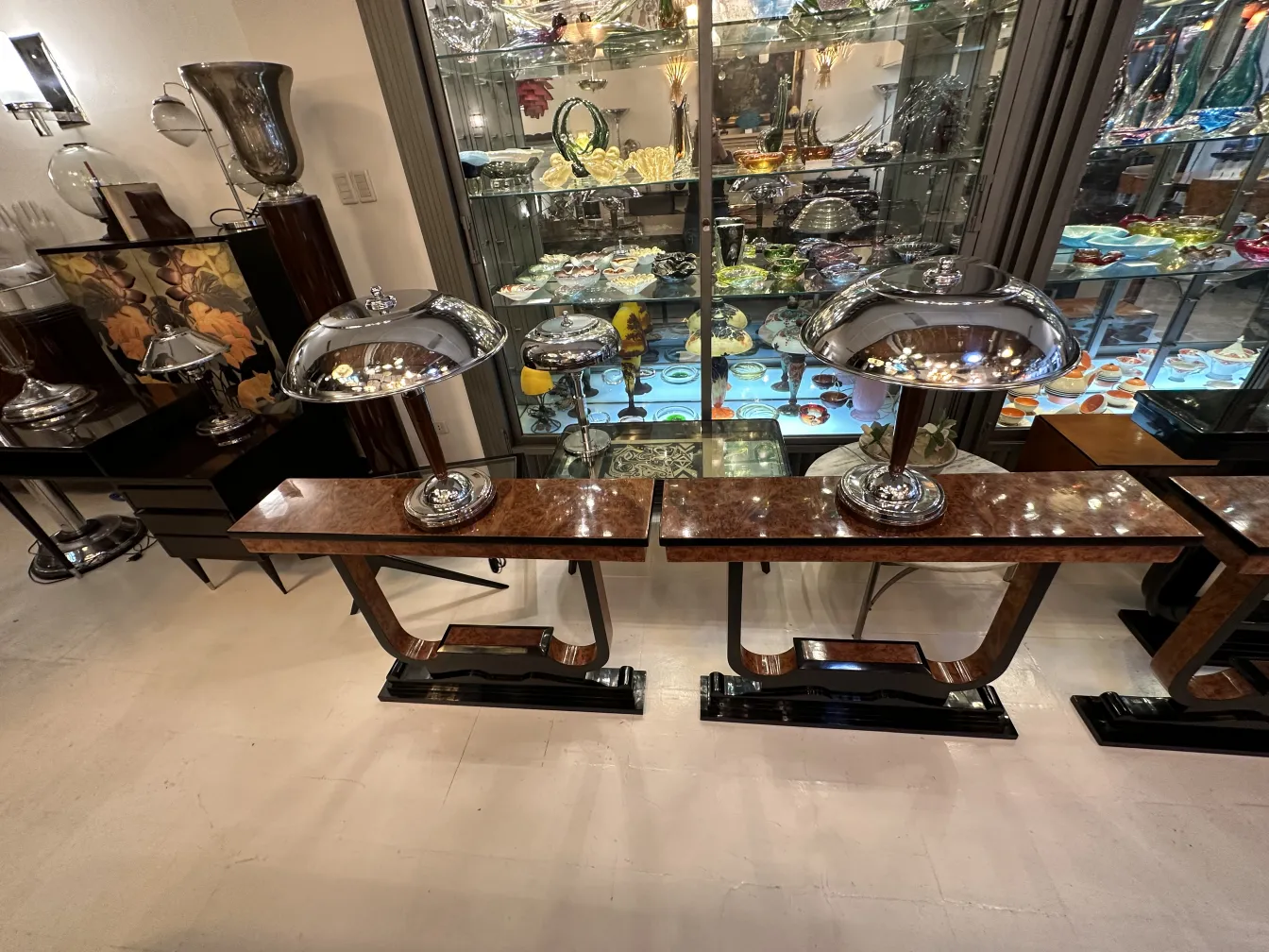 Tre mobili dresuars antichi in un ambiente elegante, con lampade luminose.