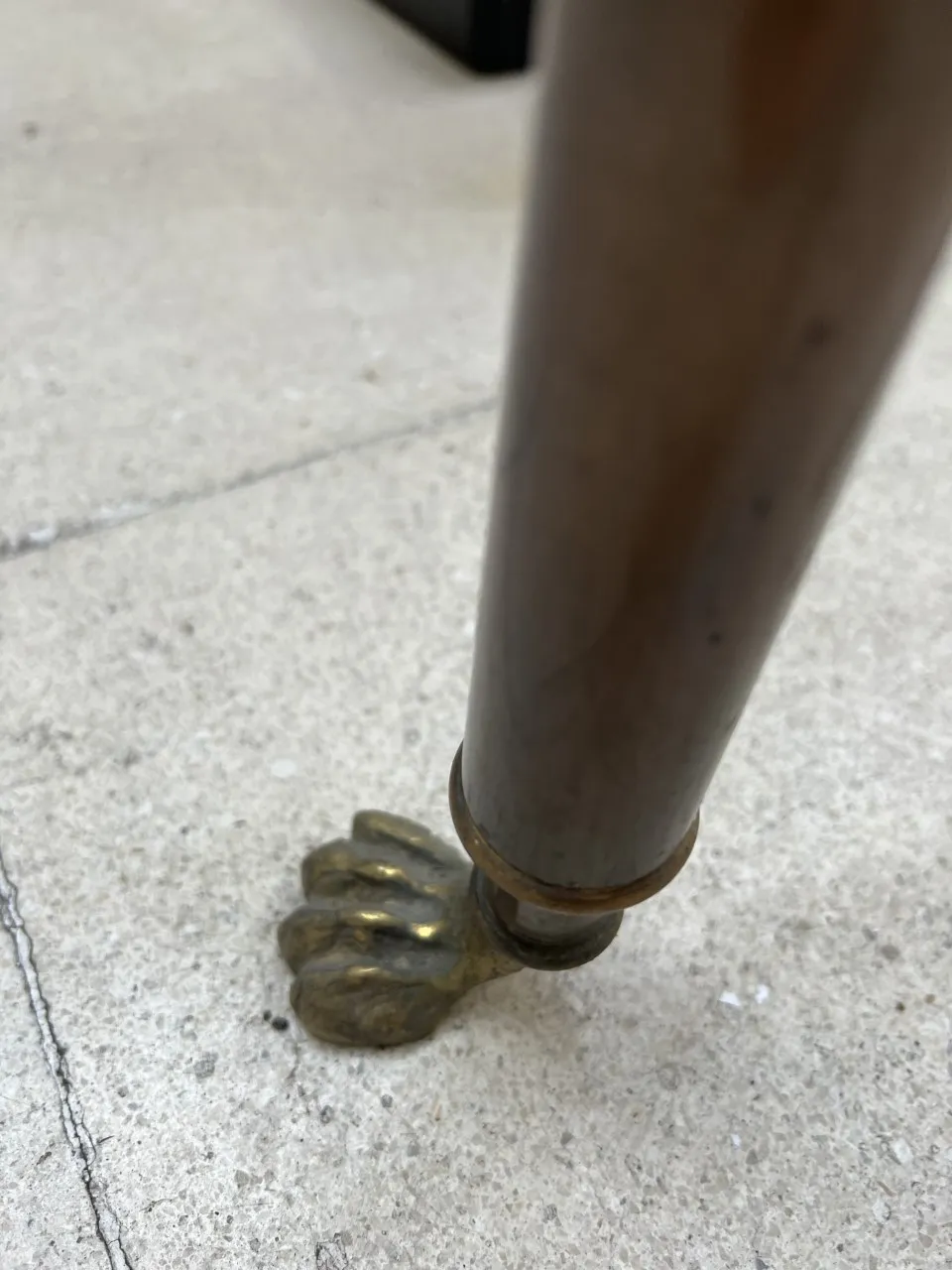 tres consolas antiguas con patas en forma de león en una superficie de cemento