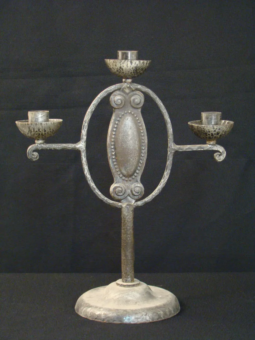 Candelabro antico con tre bracci e base rotonda.