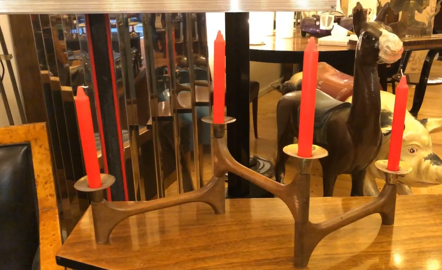 Candelabro antico a tre bracci con candele rosse in un ambiente elegante