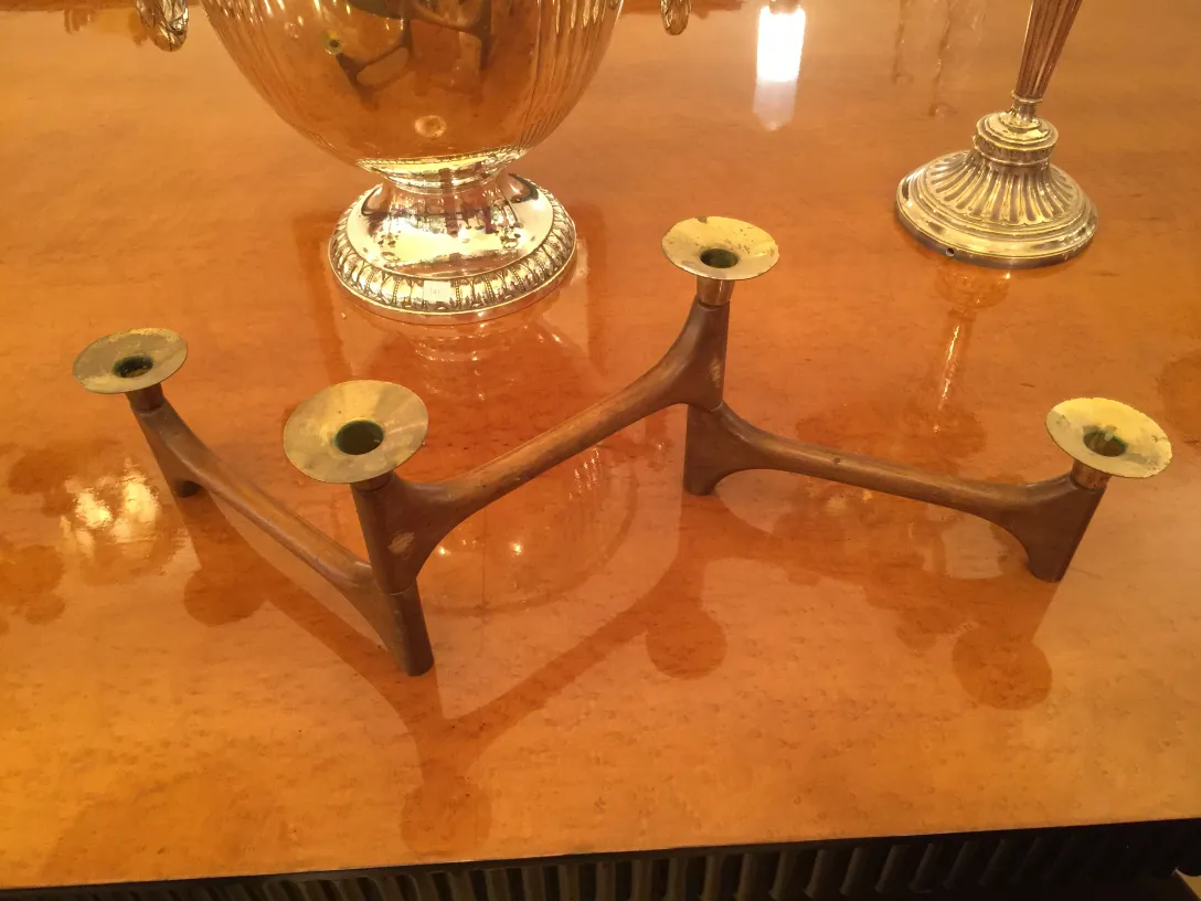 candelabra purana chamakdaar table par teen hath ka sahara