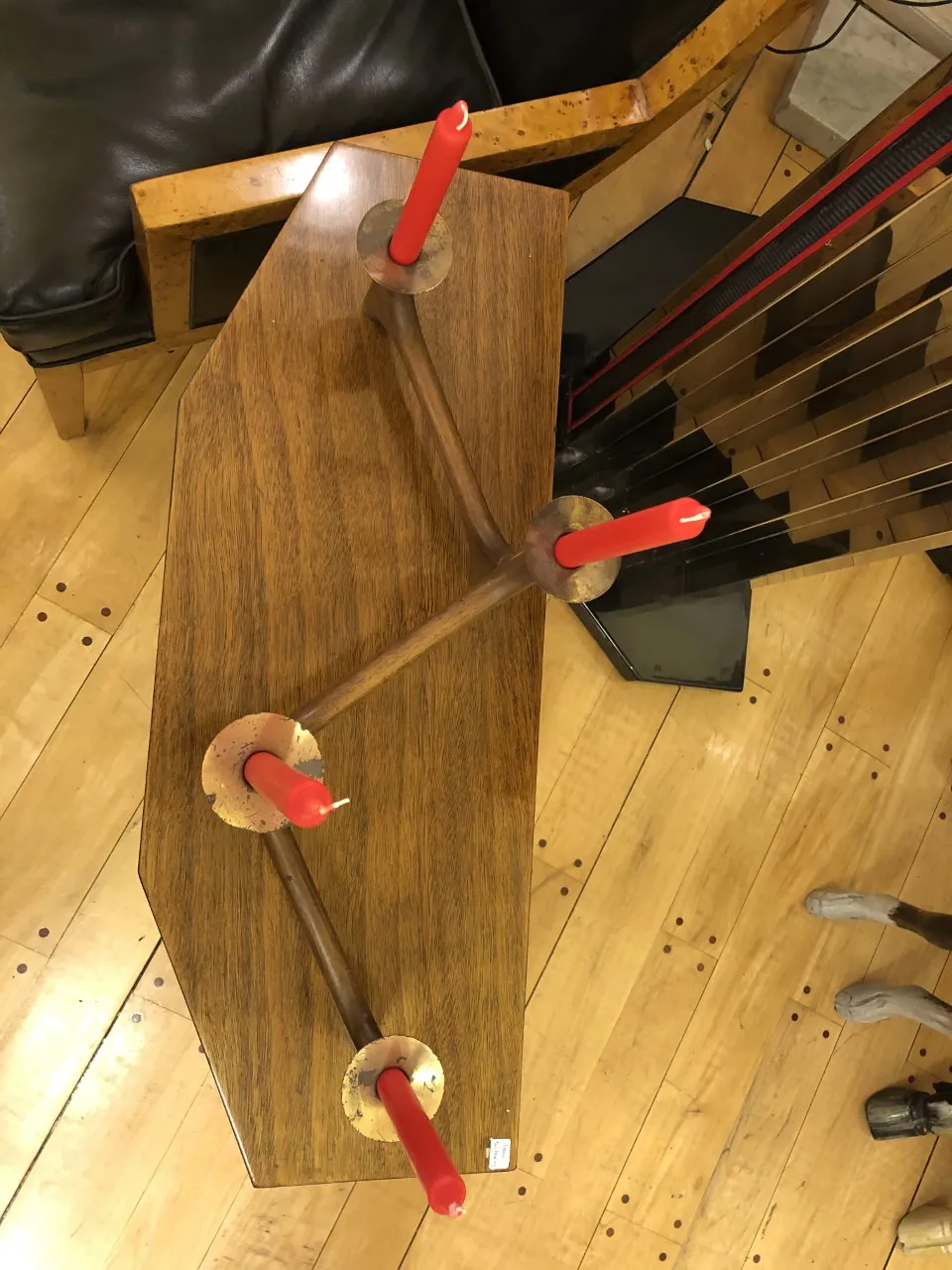 Antiker Kandelaber mit Holzbasis und roten Kerzen in einer gemütlichen Umgebung