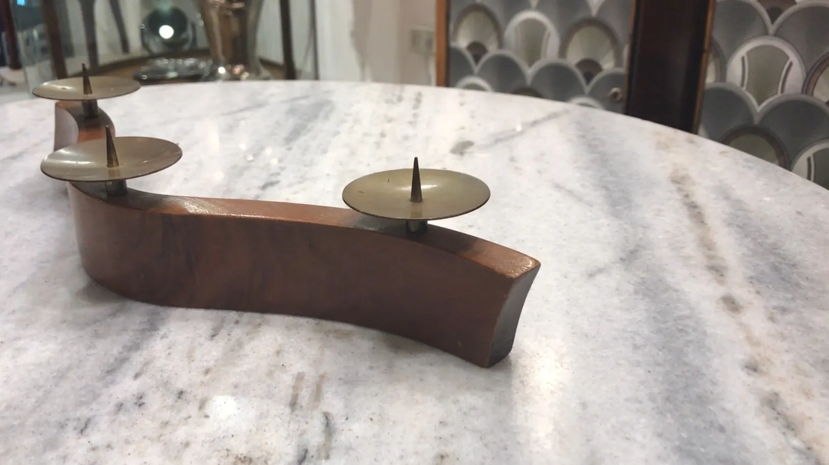 Candelabro antiguo decorativo en una mesa de mármol con ambiente elegante.