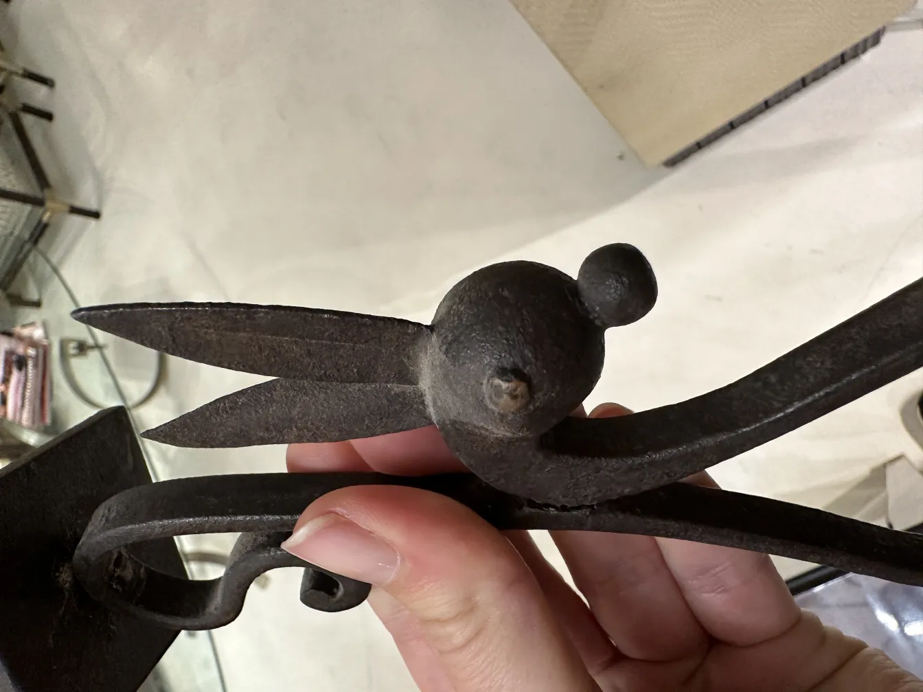 Gros plan d'un chandelier ancien décoratif, avec des détails en forme de feuille et une finition rustique dans un cadre élégant.