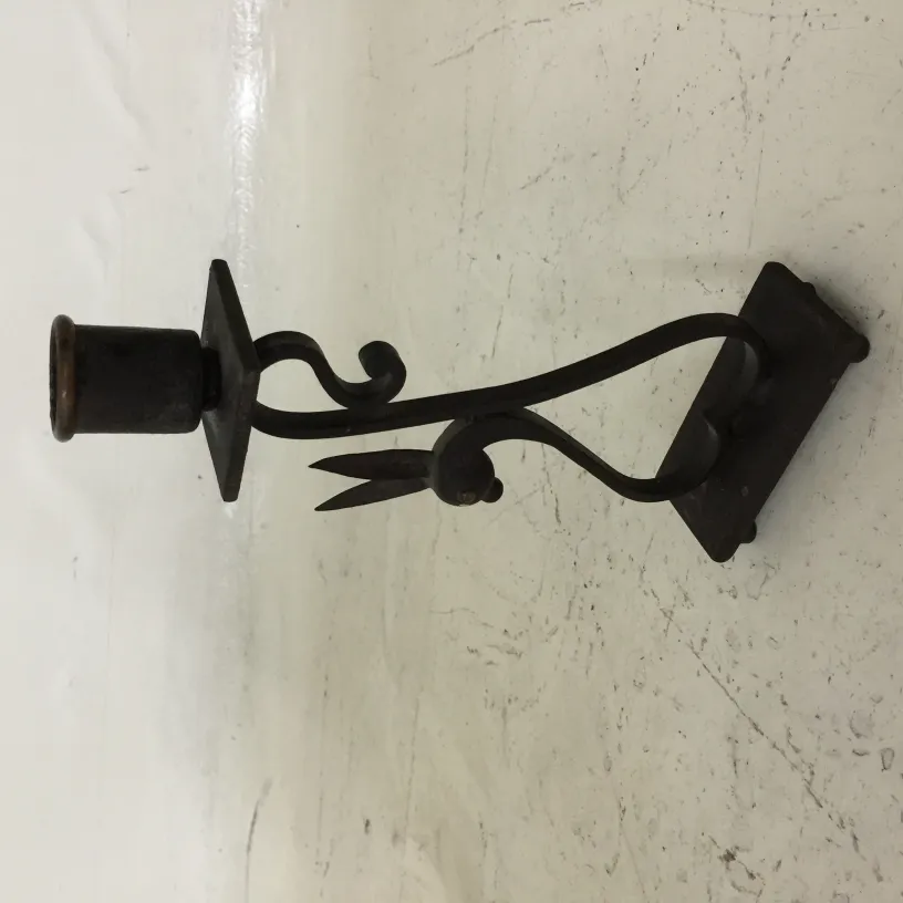 Candelabro antigo com forma elegante e detalhes decorativos em fundo claro.