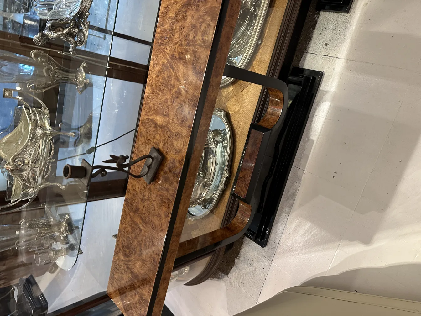 Decorative antique candelabra in front of silver platters in an elegant setting.