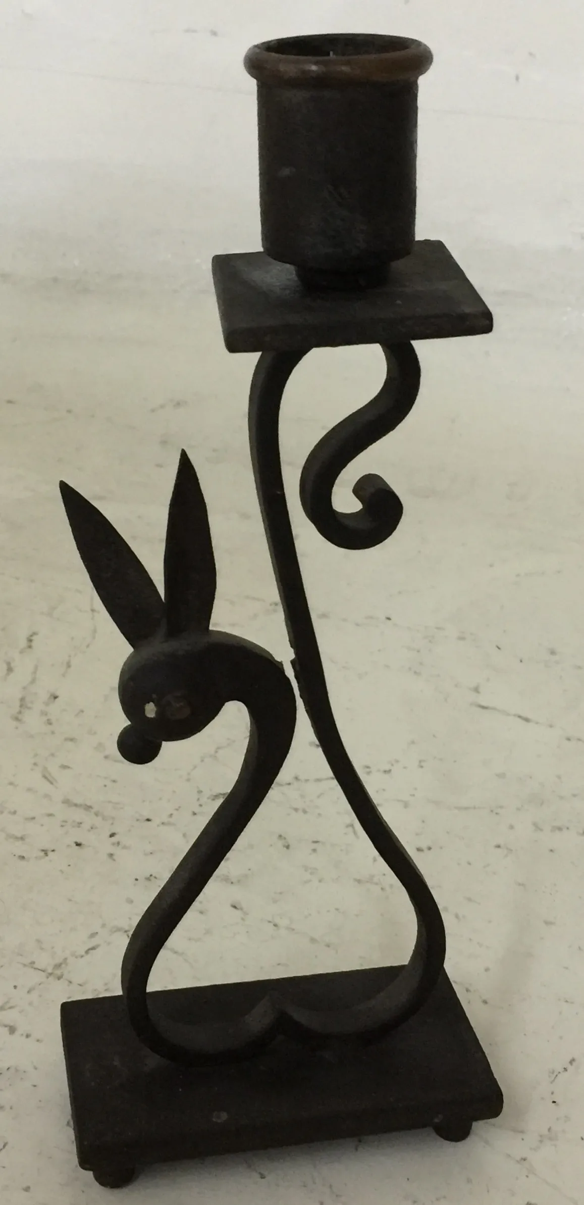 candelabro antico con base quadrata e figura di coniglio, colore scuro