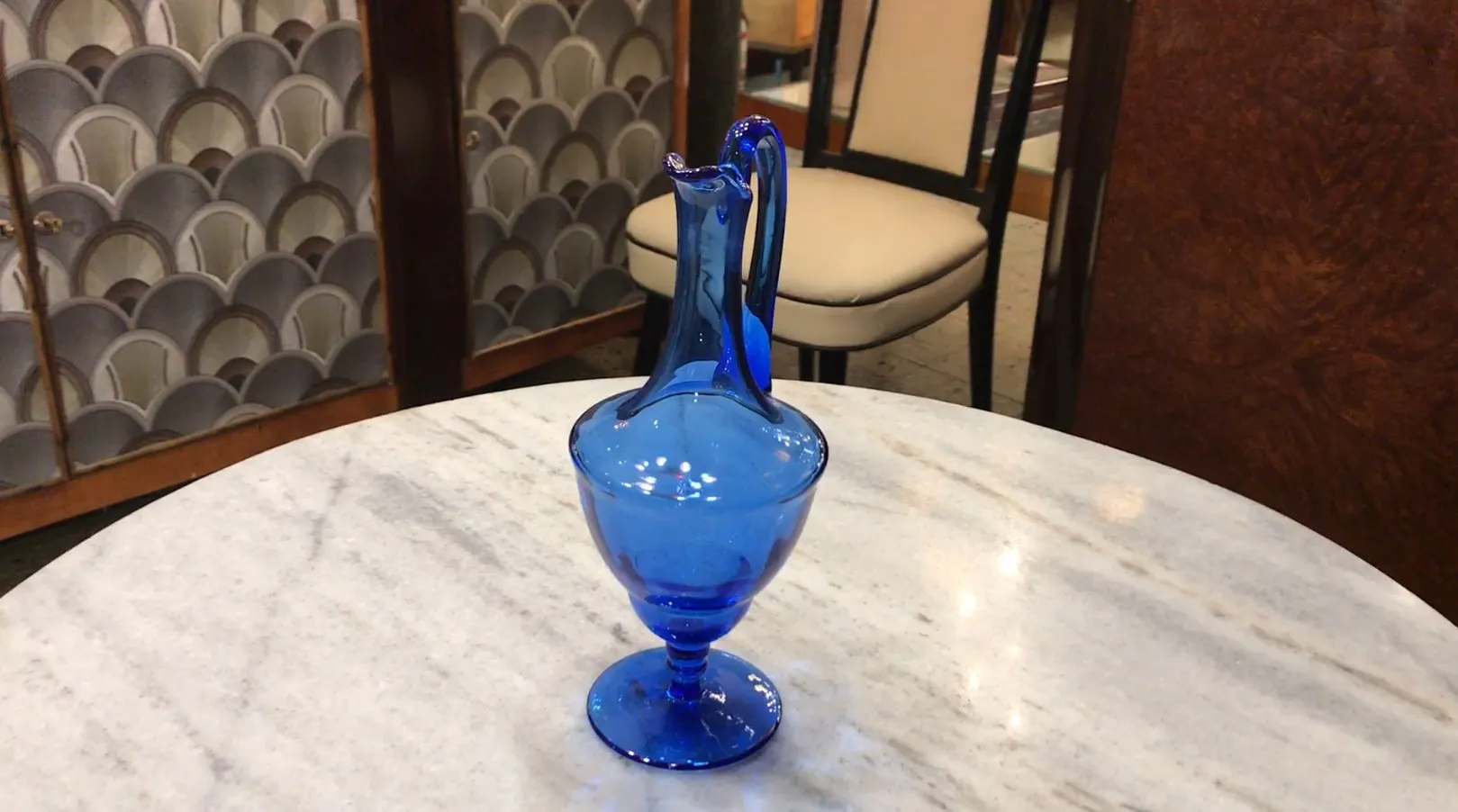 Jarra antigua azul decorativa en una mesa de mármol