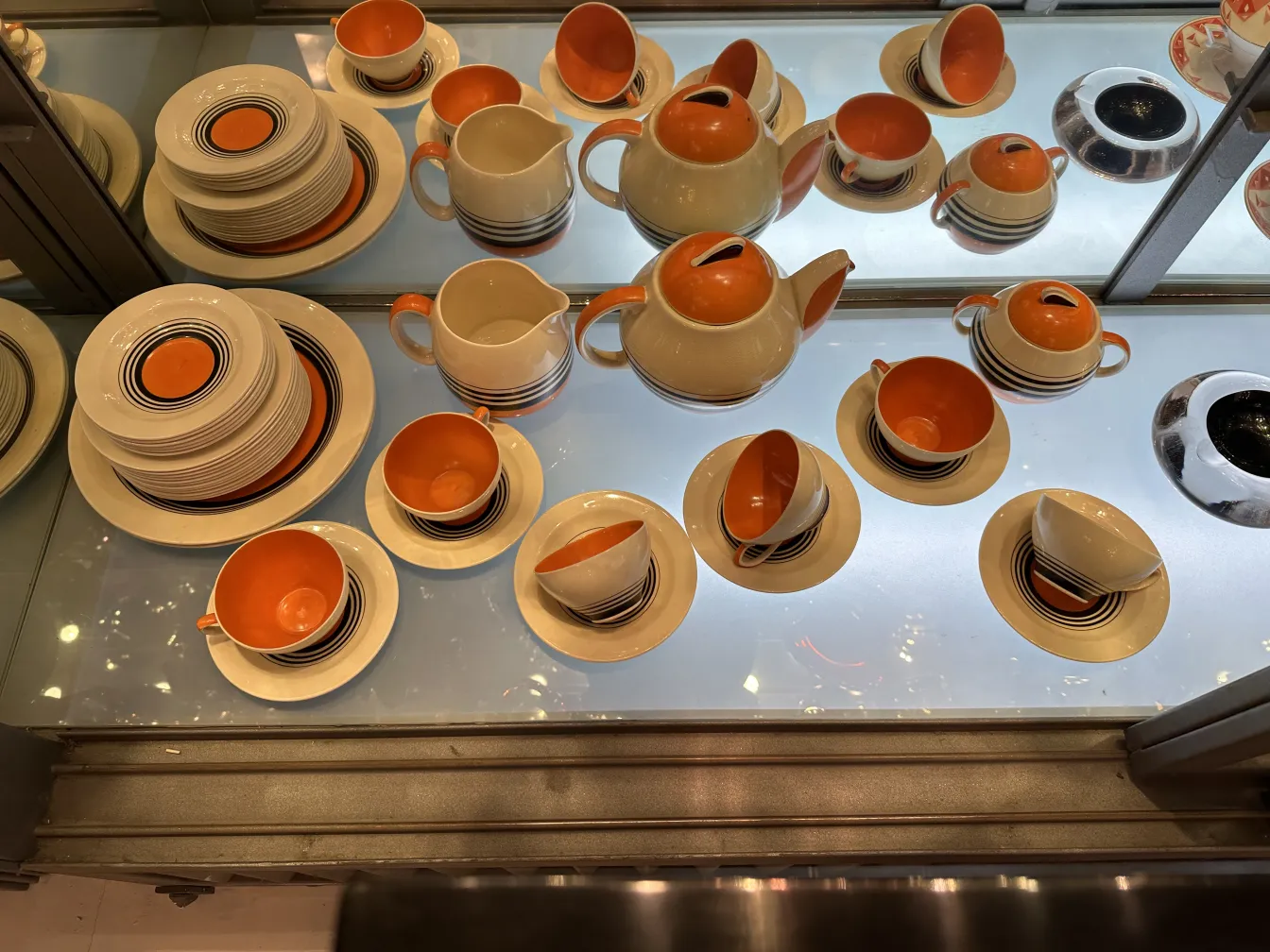 antique tea service with cream and orange cups and plates, striped details