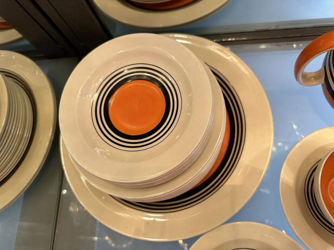 Antique tea set with colorful geometric plates and cups, elegant ambiance.