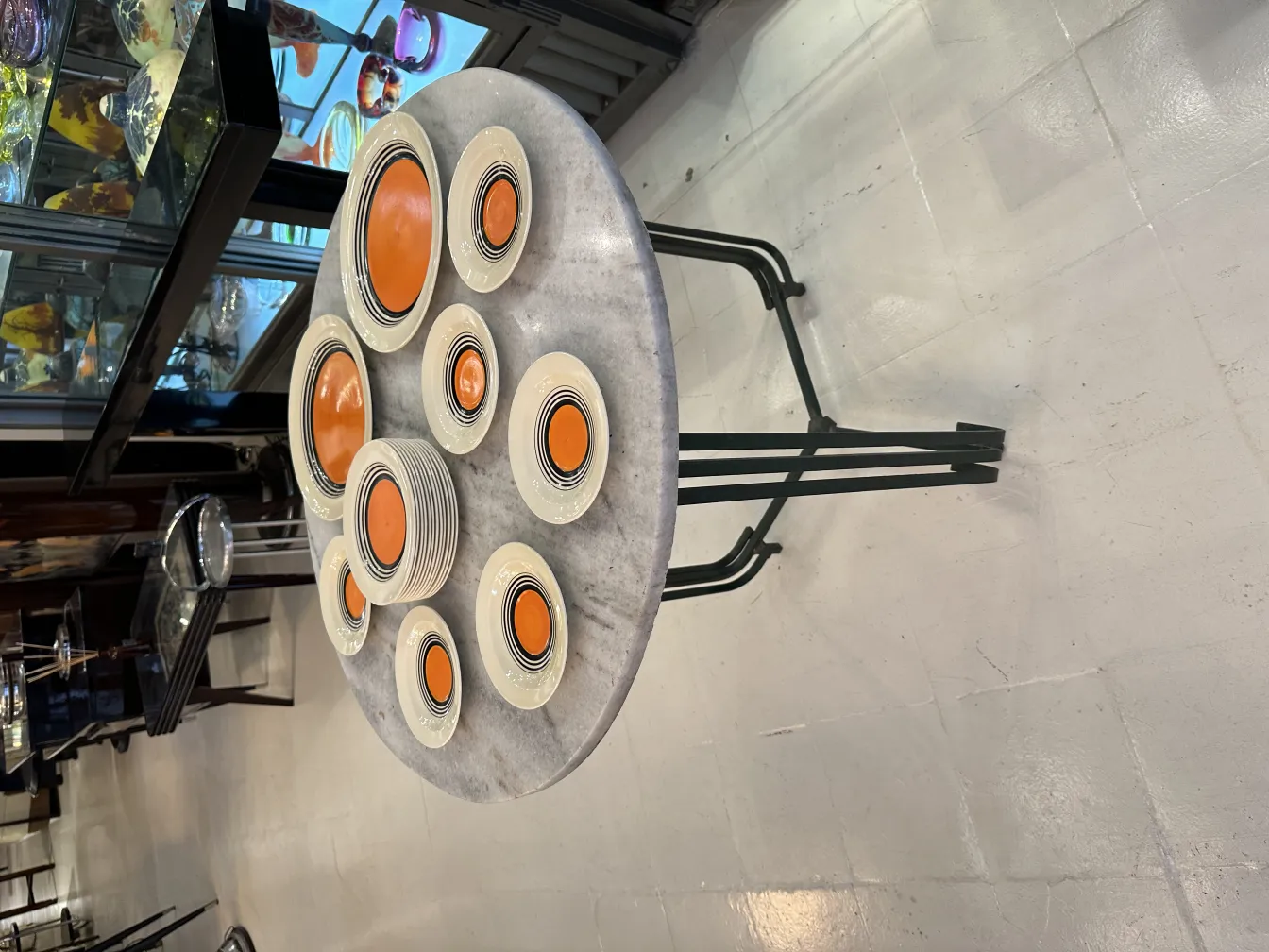 Antique tea set on table, orange and black plates creating a set, background of antiques