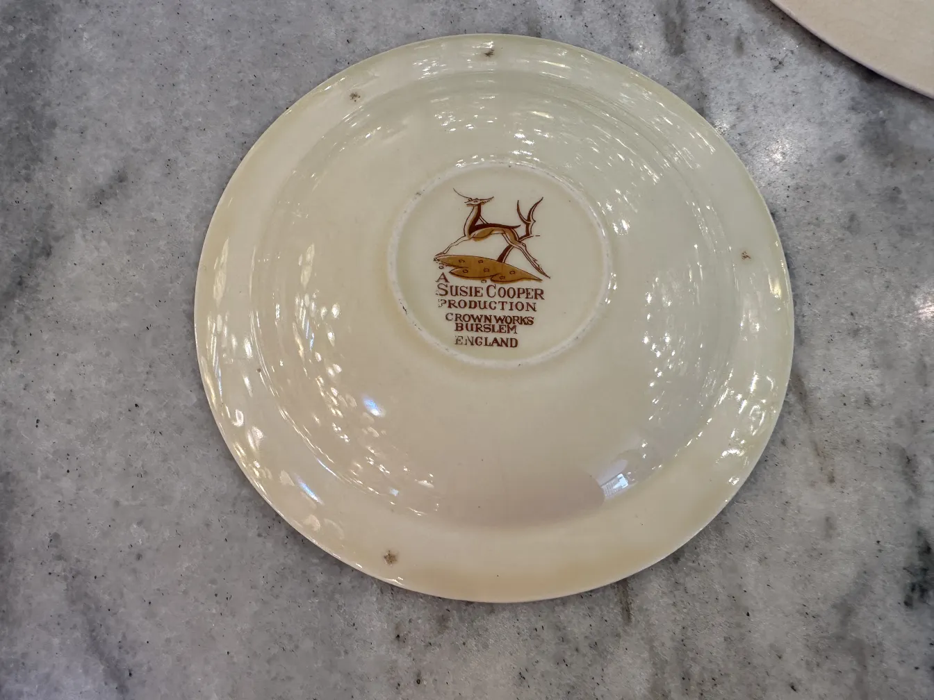 antique tea set with a decorative plate, light color and simple design, on a marble table