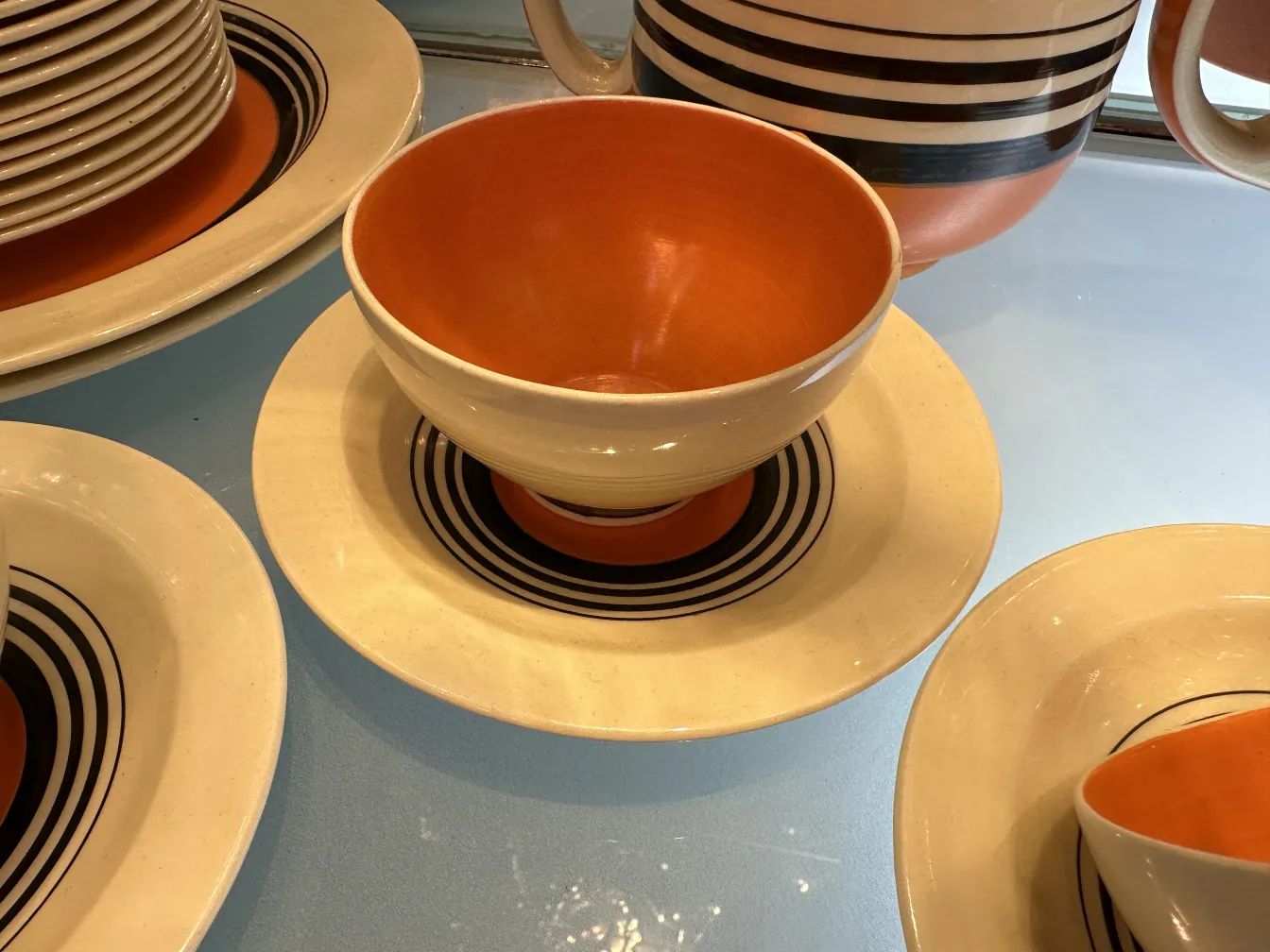 प्राचीन-चाय-सेट-भौगोलिक-डिजाइन-गरम-रंगों-में-गति-तारों-और-खिड़कियों के साथ।