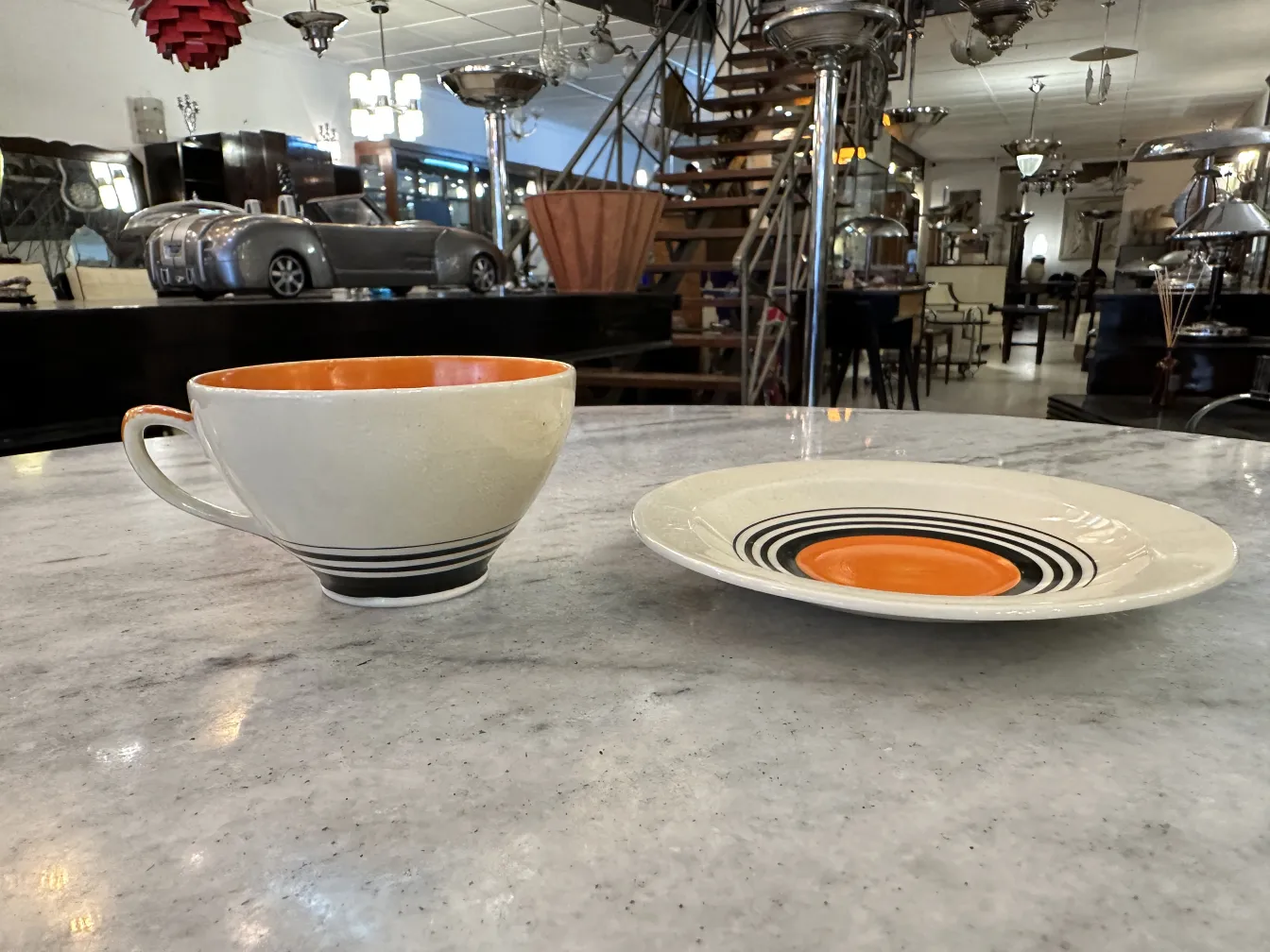 Antique tea set with decorative orange and white cups and plates