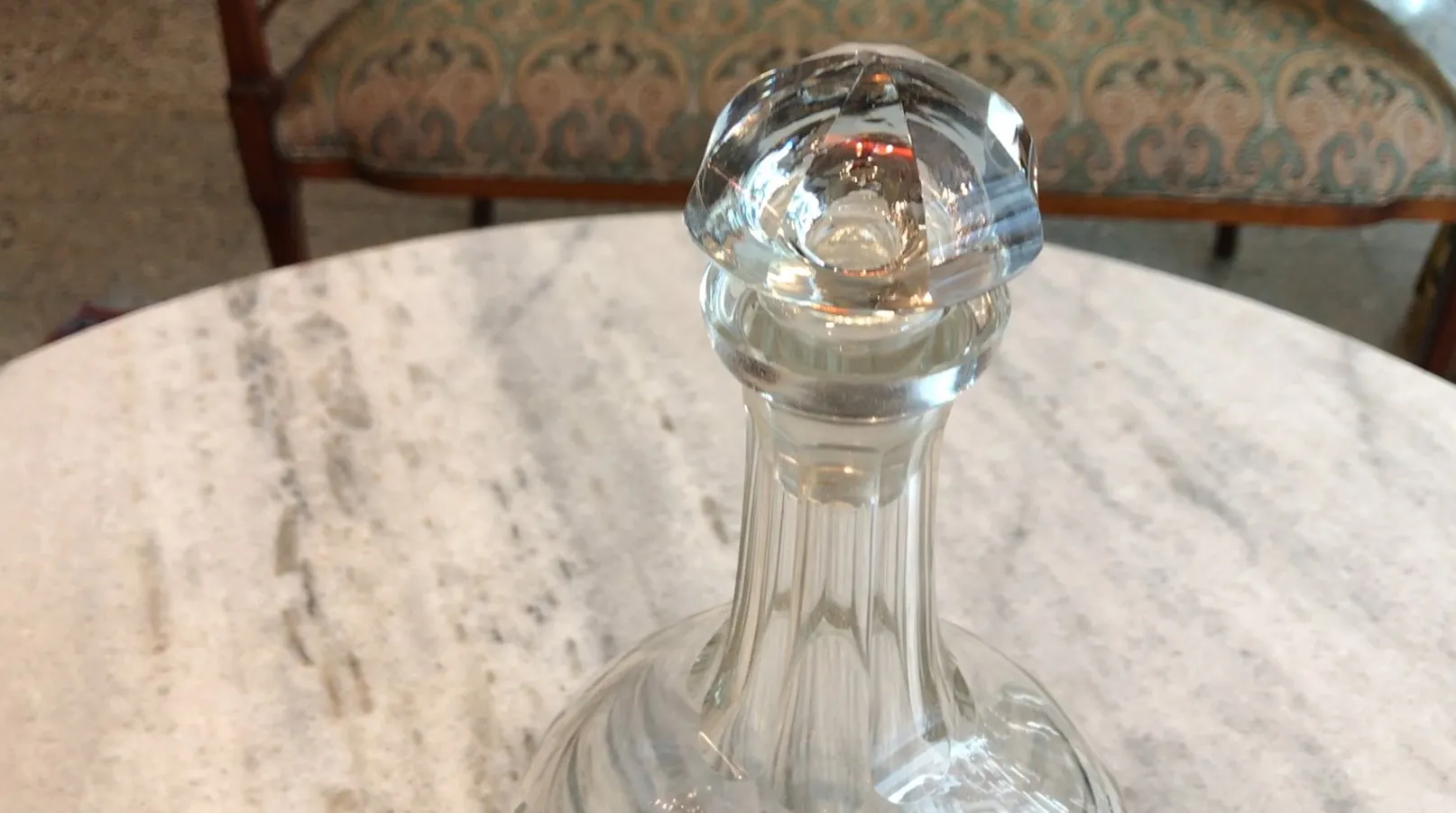 antique bottle with an elegant design and decorative stopper, on a marble table
