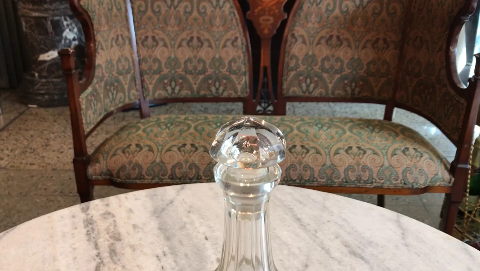 botellón antiguo de cristal con tapa de cristal, fondo en mármol
