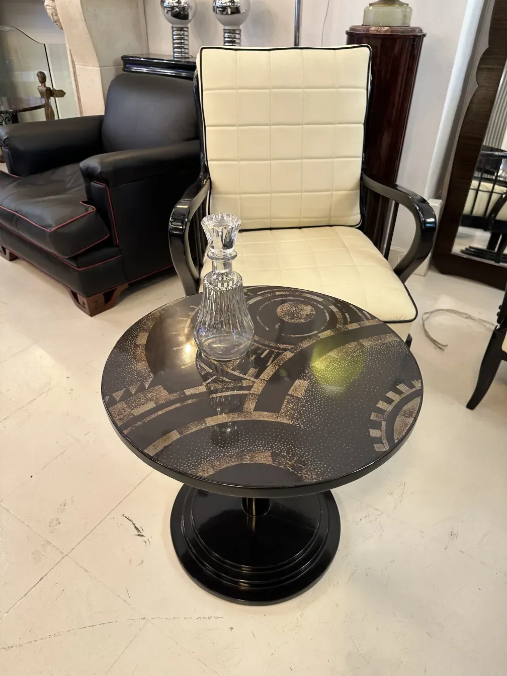 검은색 둥근 테이블 위의 고대 장식 유리 병