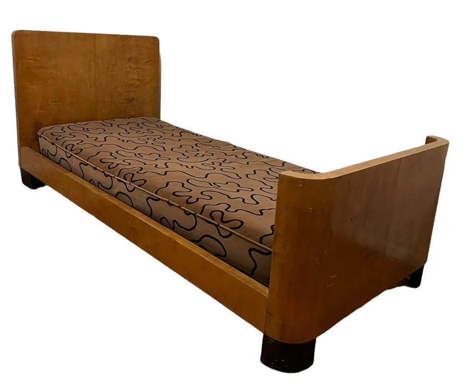 Letto antico con materasso decorato con motivi ondulati.