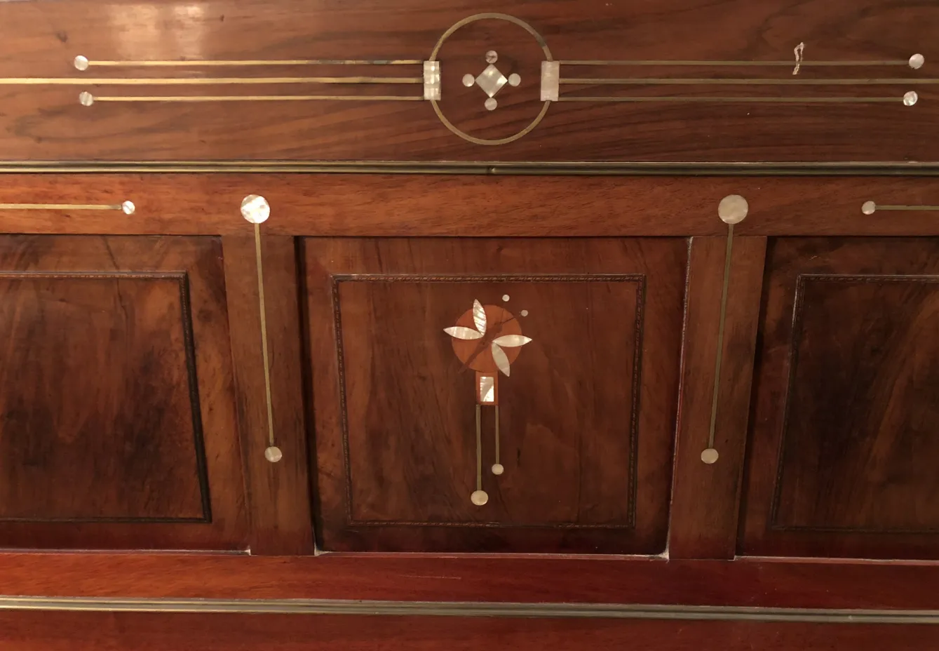 Lit ancien en bois avec détails décoratifs sur la tête de lit.