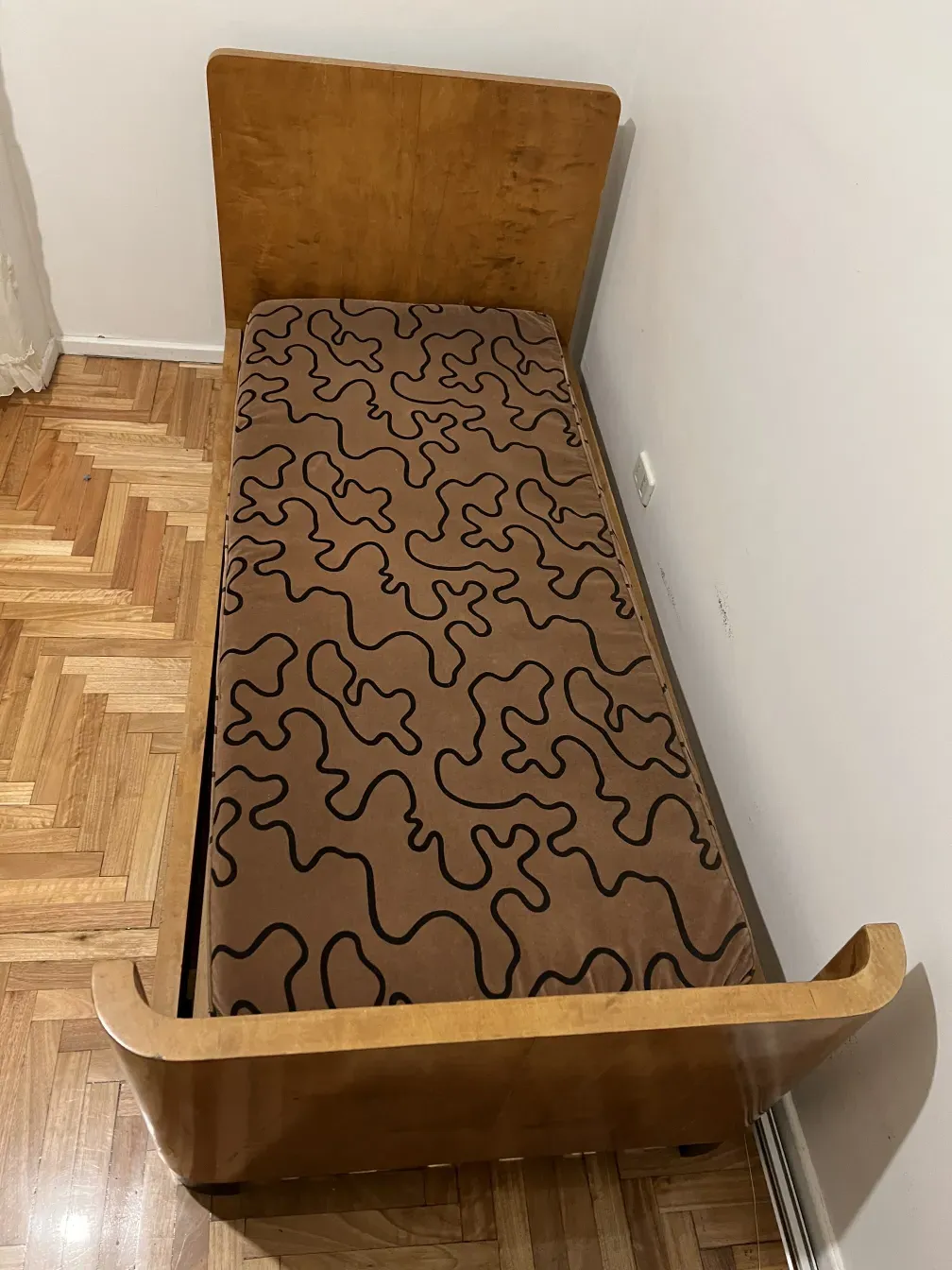 Altes Bett mit abstraktem Muster-Matratze und hellem Holz