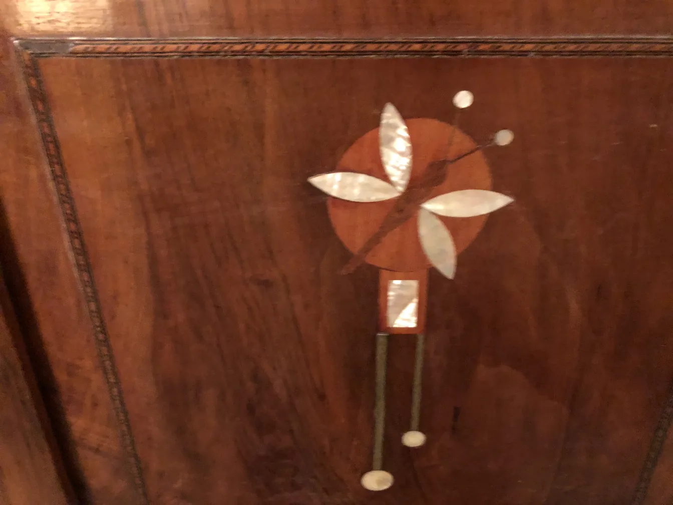 Letto antico con decorazione floreale sul legno.