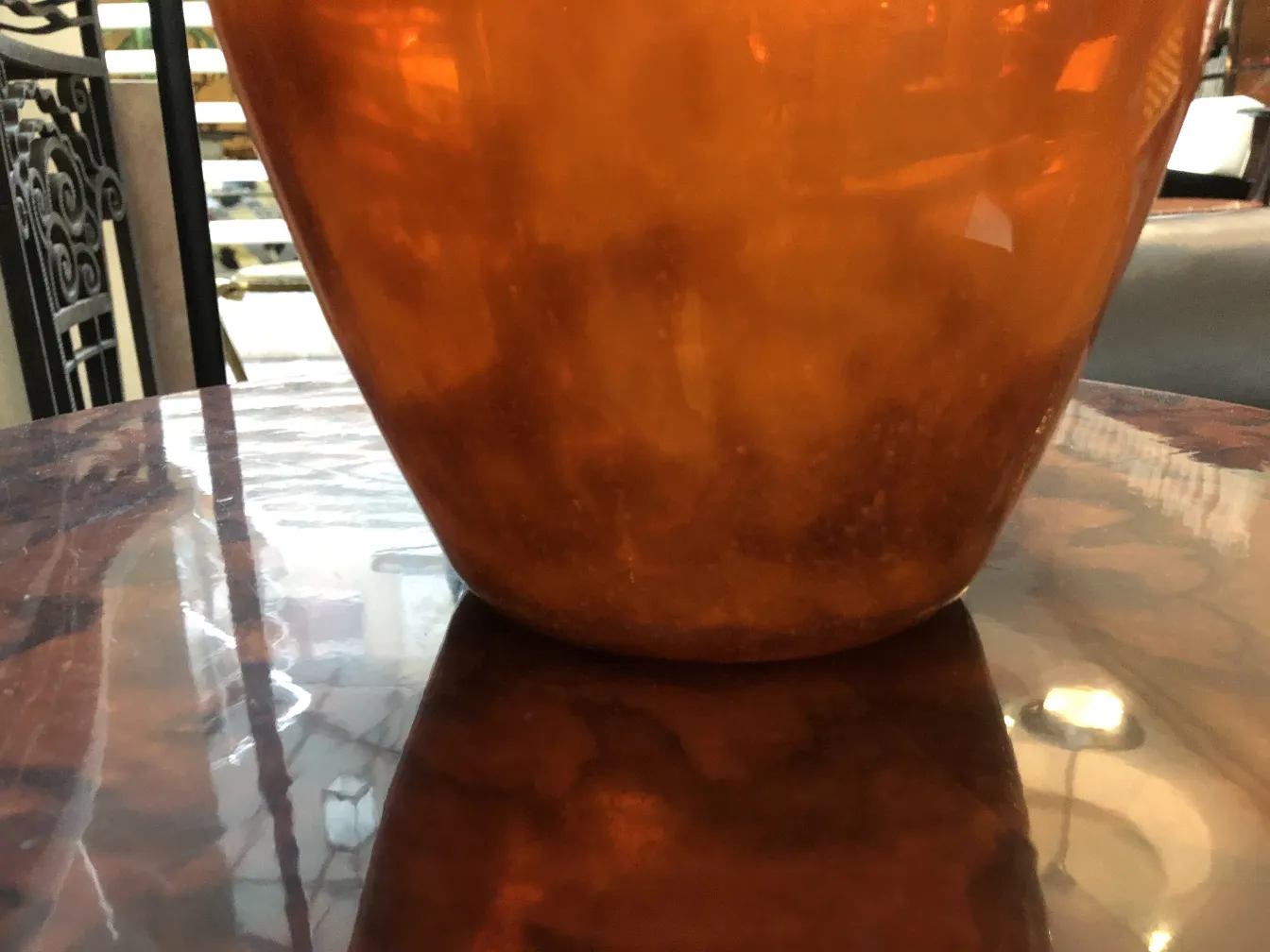 Antikes Glas mit Unterschrift Muller Fres, bernsteinfarben, auf Tischoberfläche.