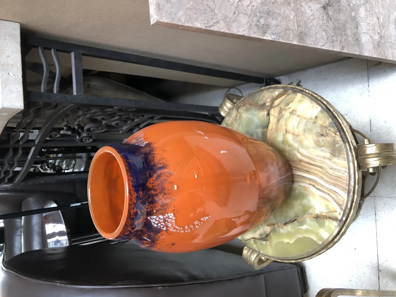 Vaso di vetro antico con firma Muller Fres in arancione e blu, ambientato in un contesto classico.