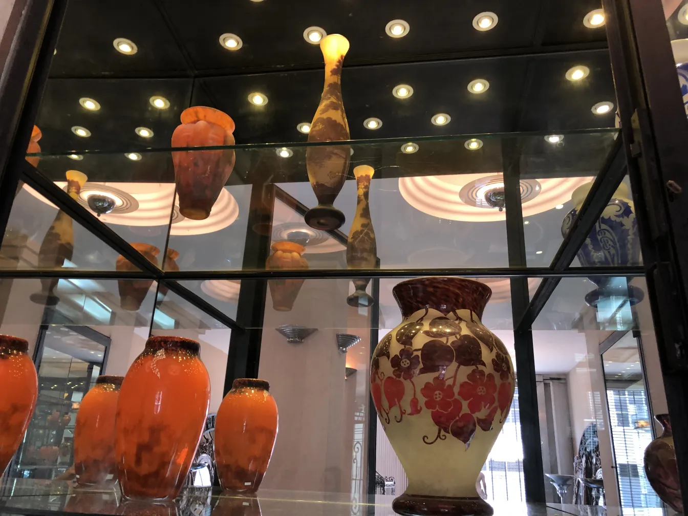 प्रदर्शनी में प्राचीन कांच के बर्तन, मोलर फ़्रेरेस के हस्ताक्षरित कांच पर जोर देने के साथ