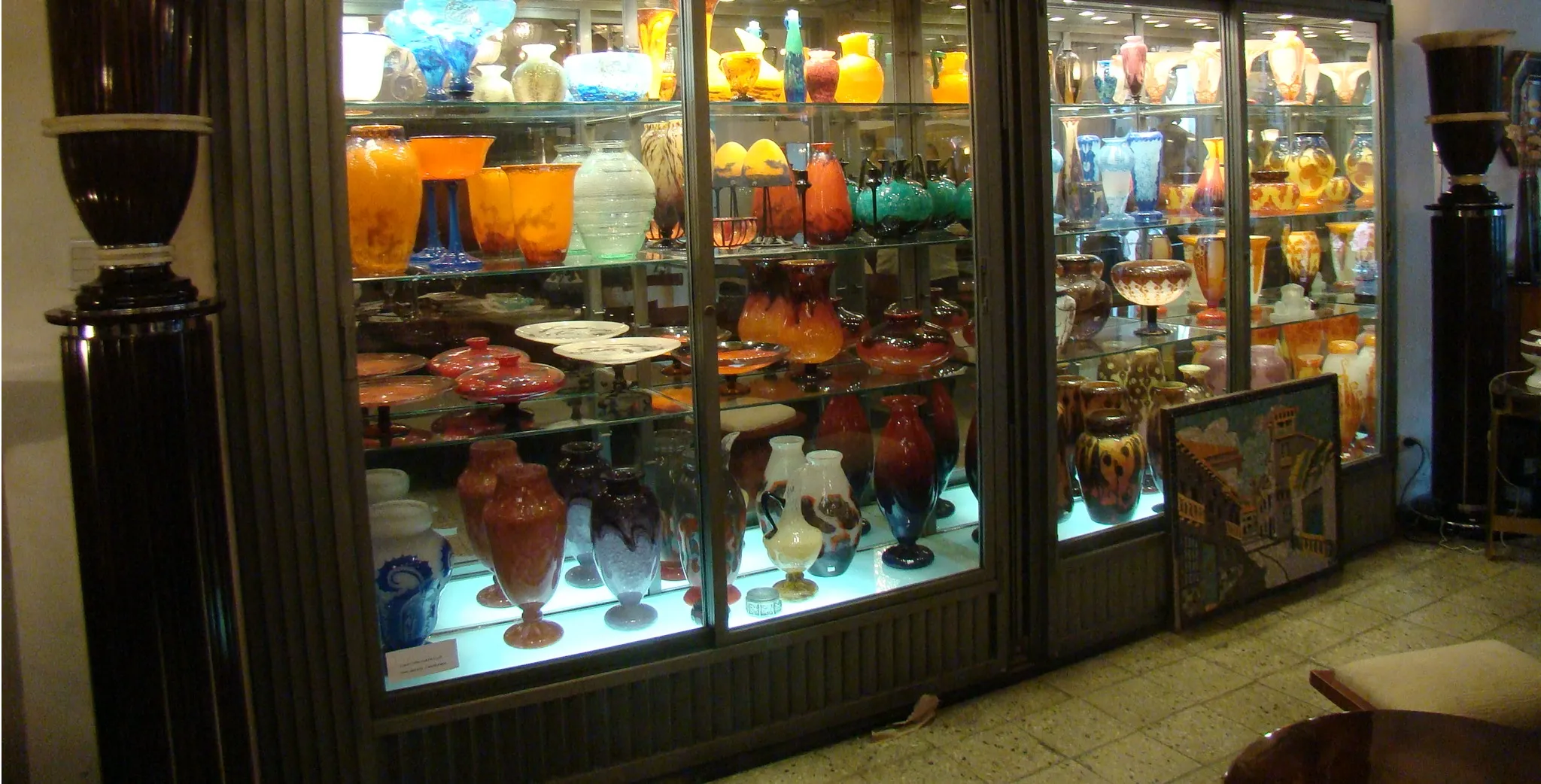 Display case with various vases and antique glass, including signed Muller Fres.