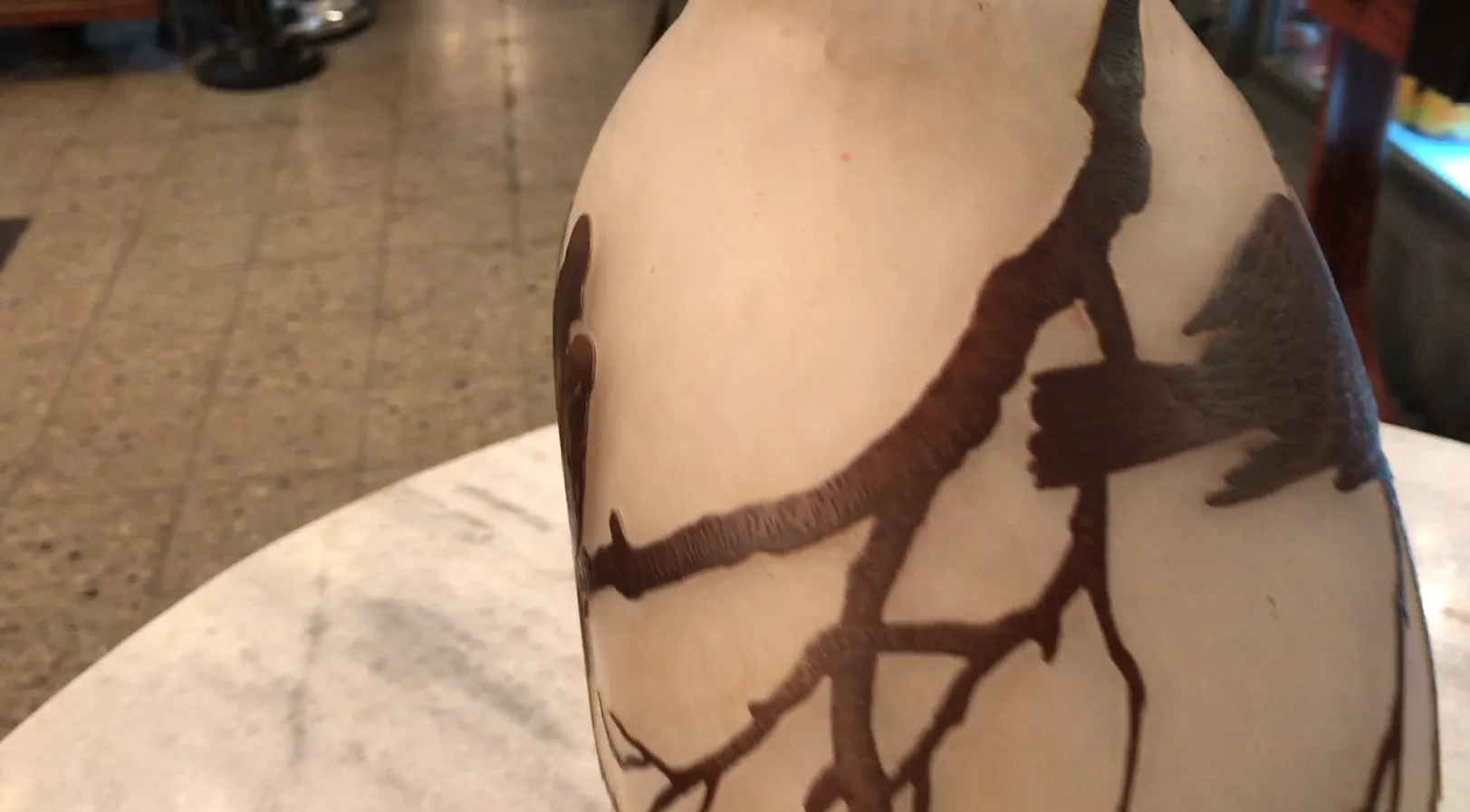 Vetro antico firmato con design di rami in contesto di antiquariato