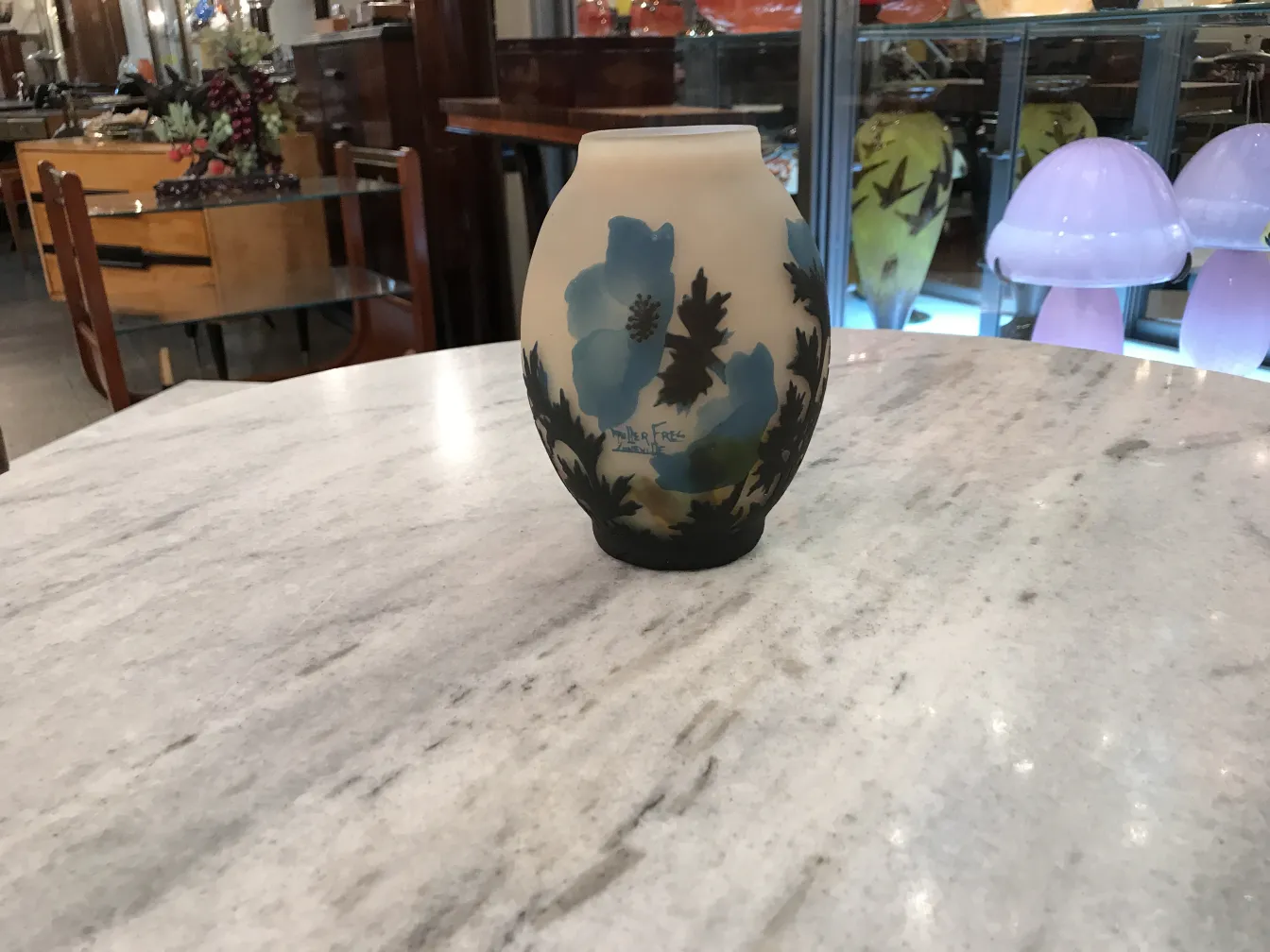 vaso com flores azuis, assinatura visível muller freres, ambiente de antiguidades.