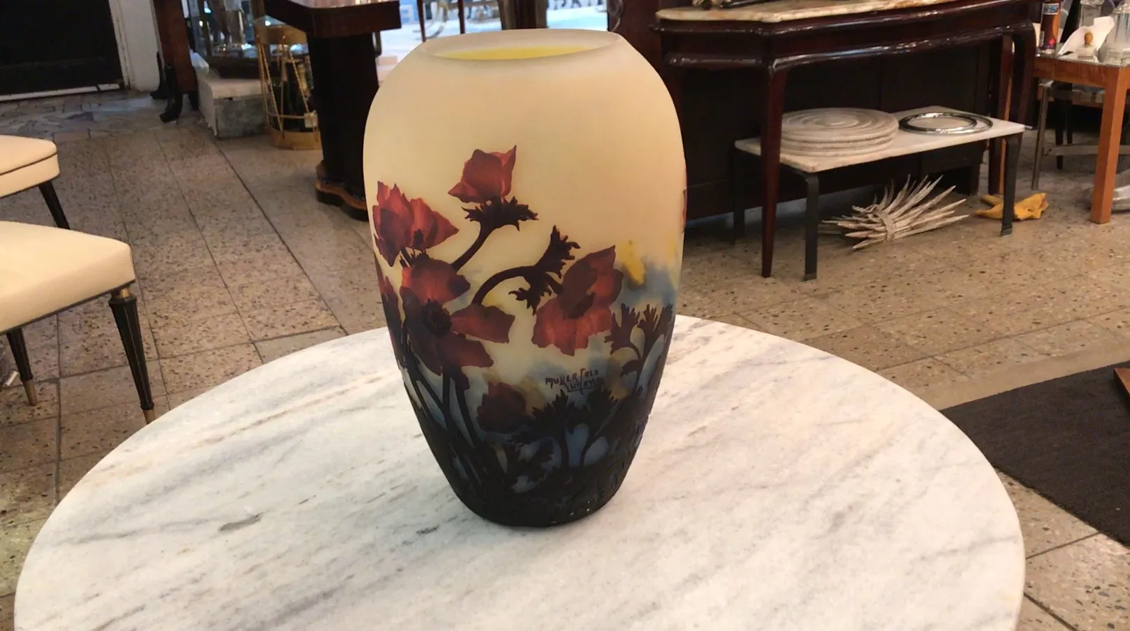 vase of signed glass muller fres with red flowers and light background