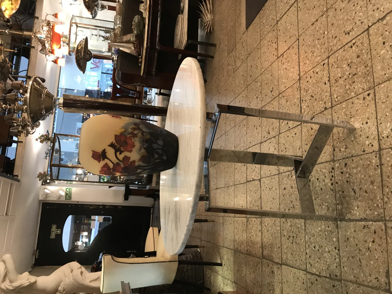 Antiguidade com flores desenhadas, vidro assinado Muller Fres em ambiente vintage.