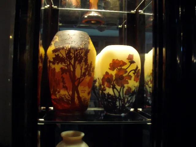 two vases of signed glass Muller Freres in display case with natural motifs