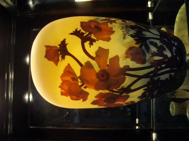 Vase mit signiertem Glas und buntem Blumendesign.