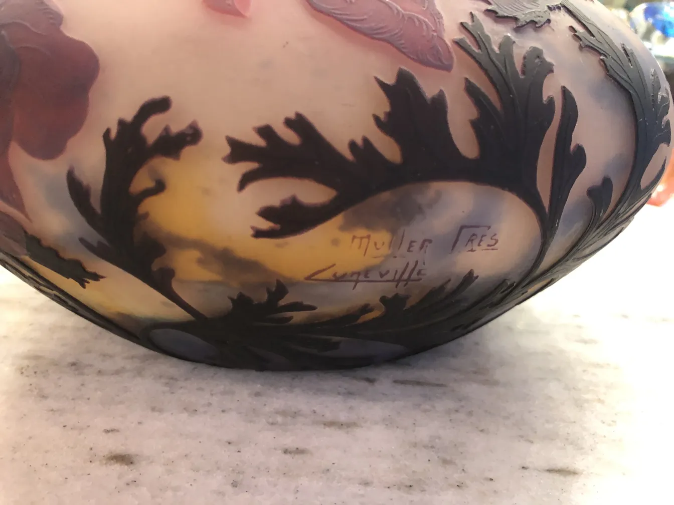 Antique signed glass by Muller Fres with decorative elements in the background