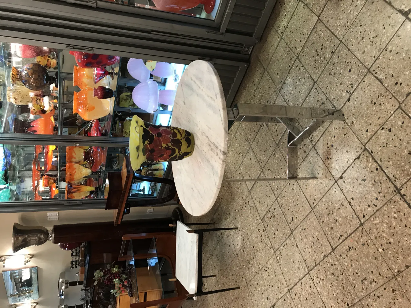 Pièce de verre antique avec la signature de Muller Fres, présentant des couleurs variées et des formes esthétiques, entourée d'objets décoratifs.