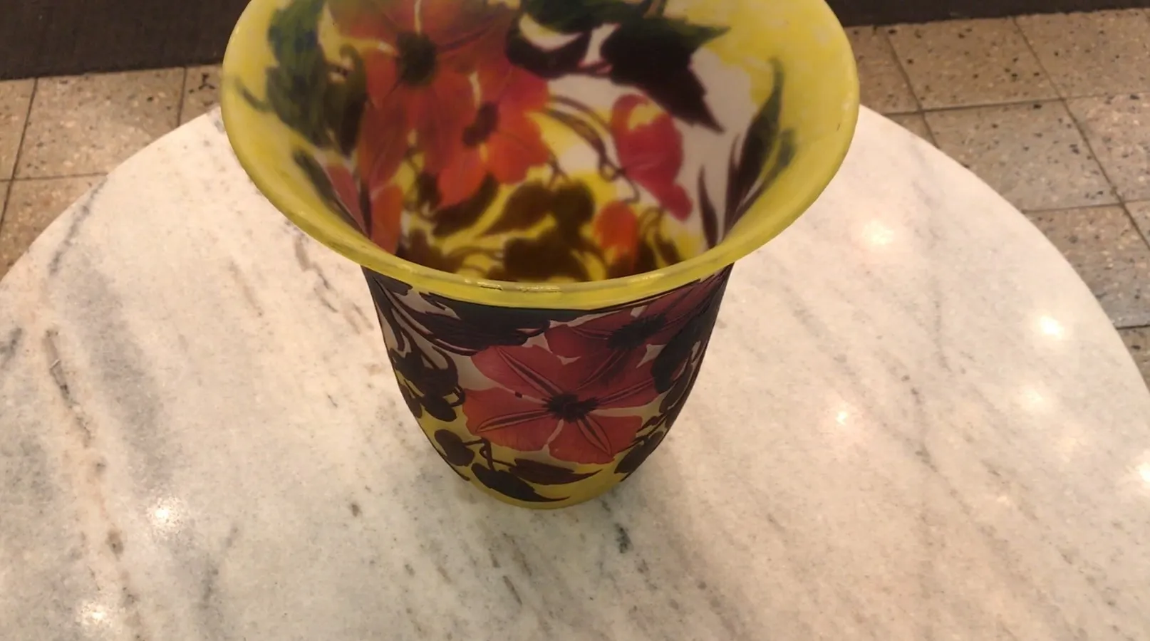 Vaso antiquado assinado por Muller Fres com um design floral colorido em um ambiente elegante.