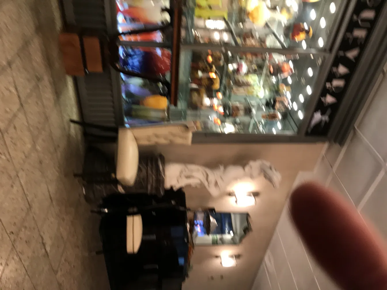 Vidro assinado Muller Fres, antiguidade, exposto com vários itens decorativos coloridos na loja.