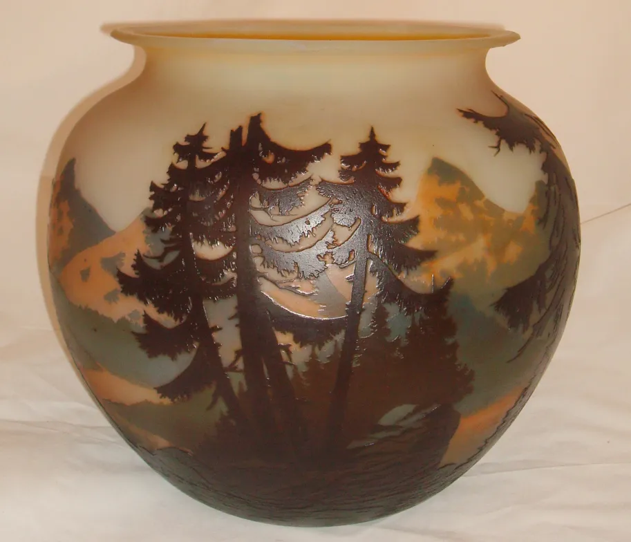 Un vetro con un design di paesaggio montano e alberi, firmato Muller Fres.