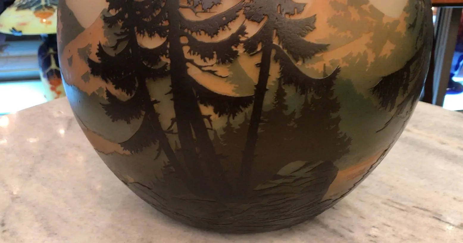 Antique signed glass with tree design in earthy tones.