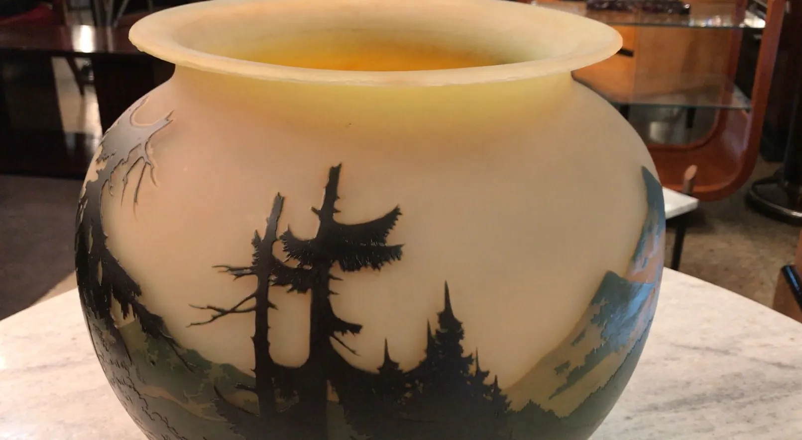 Signed glass featuring a soft conifer landscape