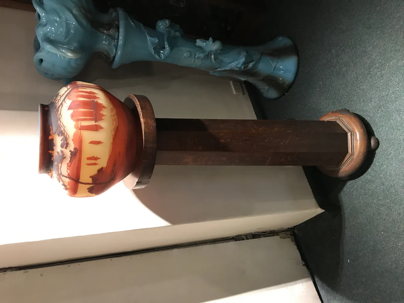 Vidro assinado Muller Fres em um suporte decorativo, fundo de ambiente antigo.