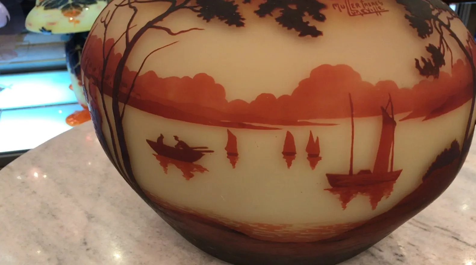 Antique signed glass Muller Fres depicting a warm landscape with boats.