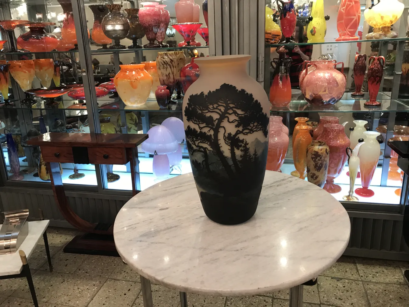 Jarrón antiguo con diseño de árbol de Muller Freres en un entorno decorativo.