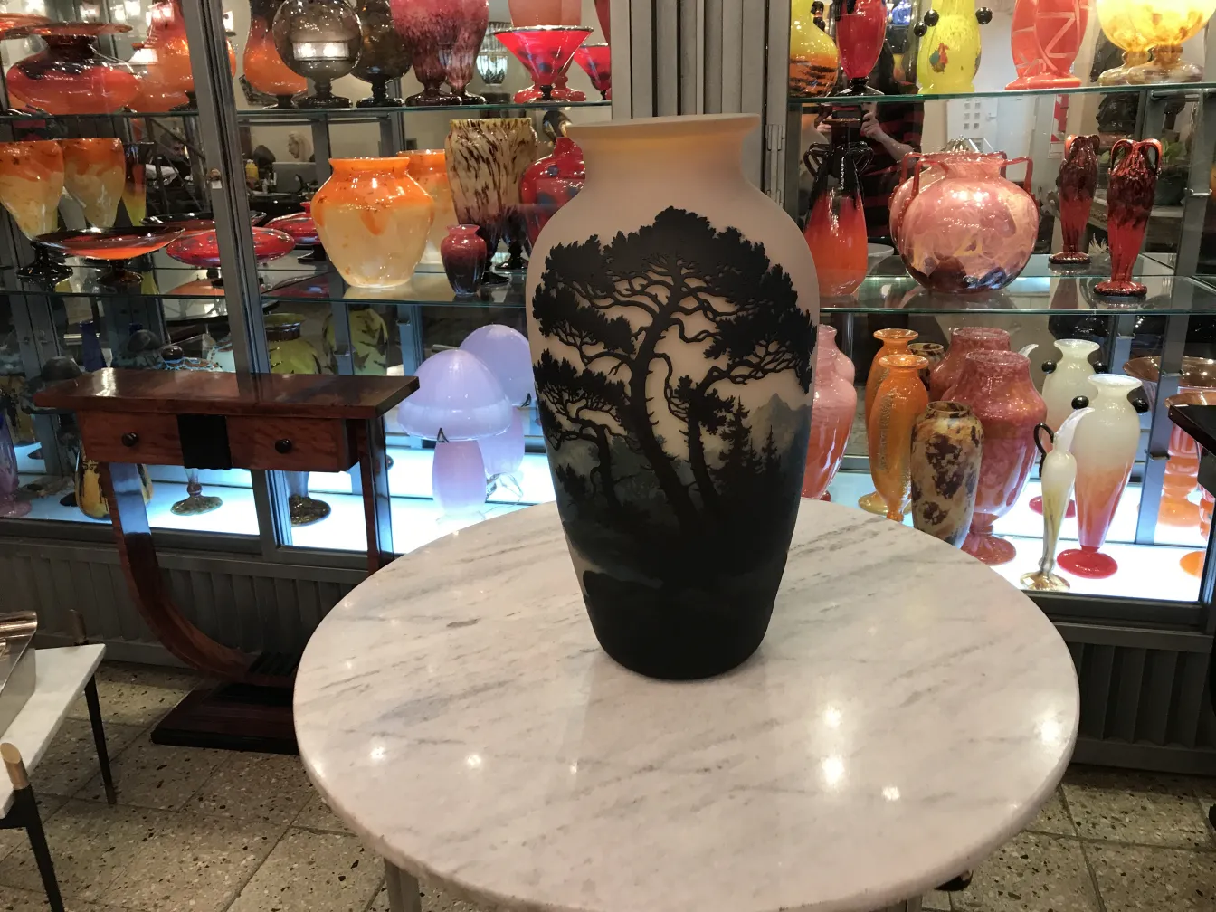 美丽的古董花瓶，上面有Muller Fres的签名，周围是五彩缤纷的玻璃制品。