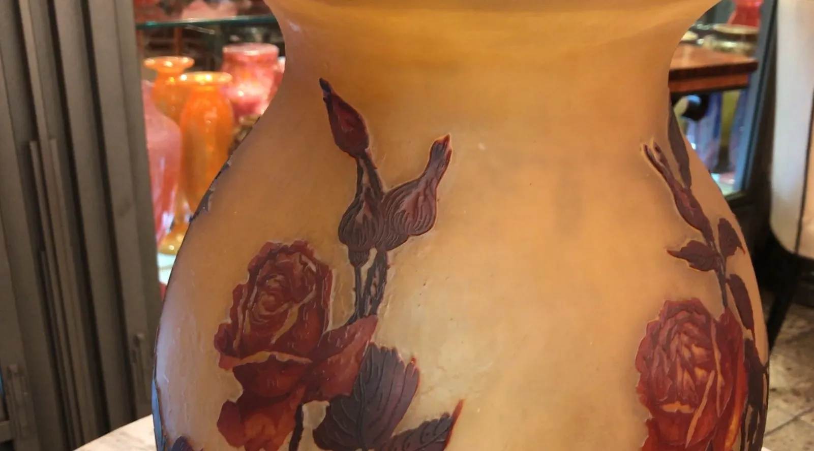 Antike Vase mit Rosendesign und Blättern, muller fres, warme Atmosphäre.