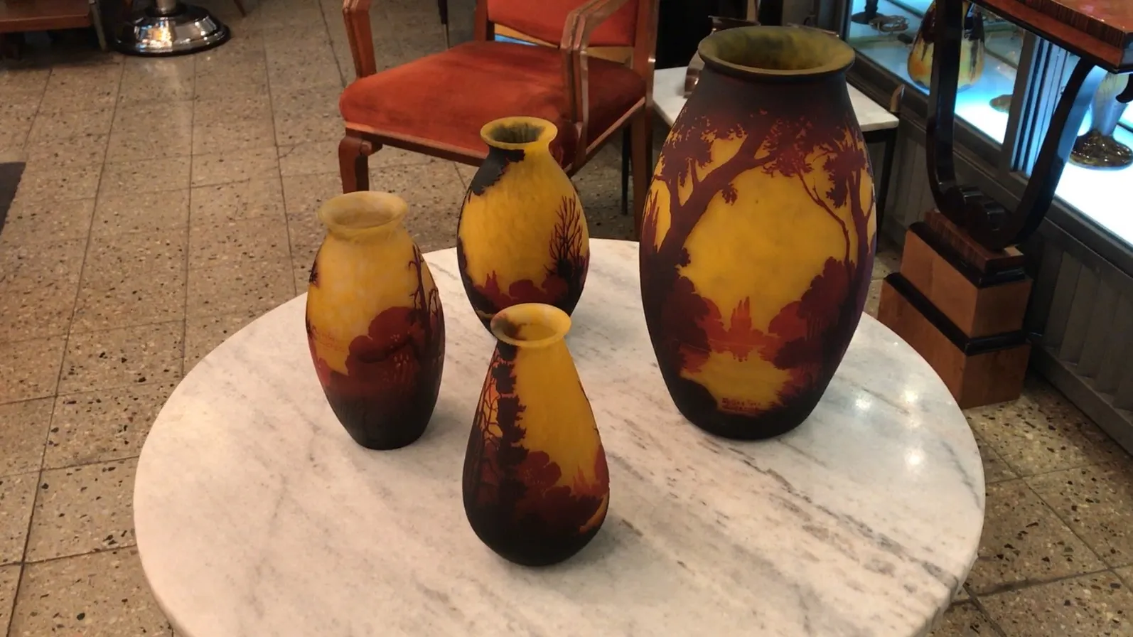 Signed glass by Muller Freres, displayed among antique vases.