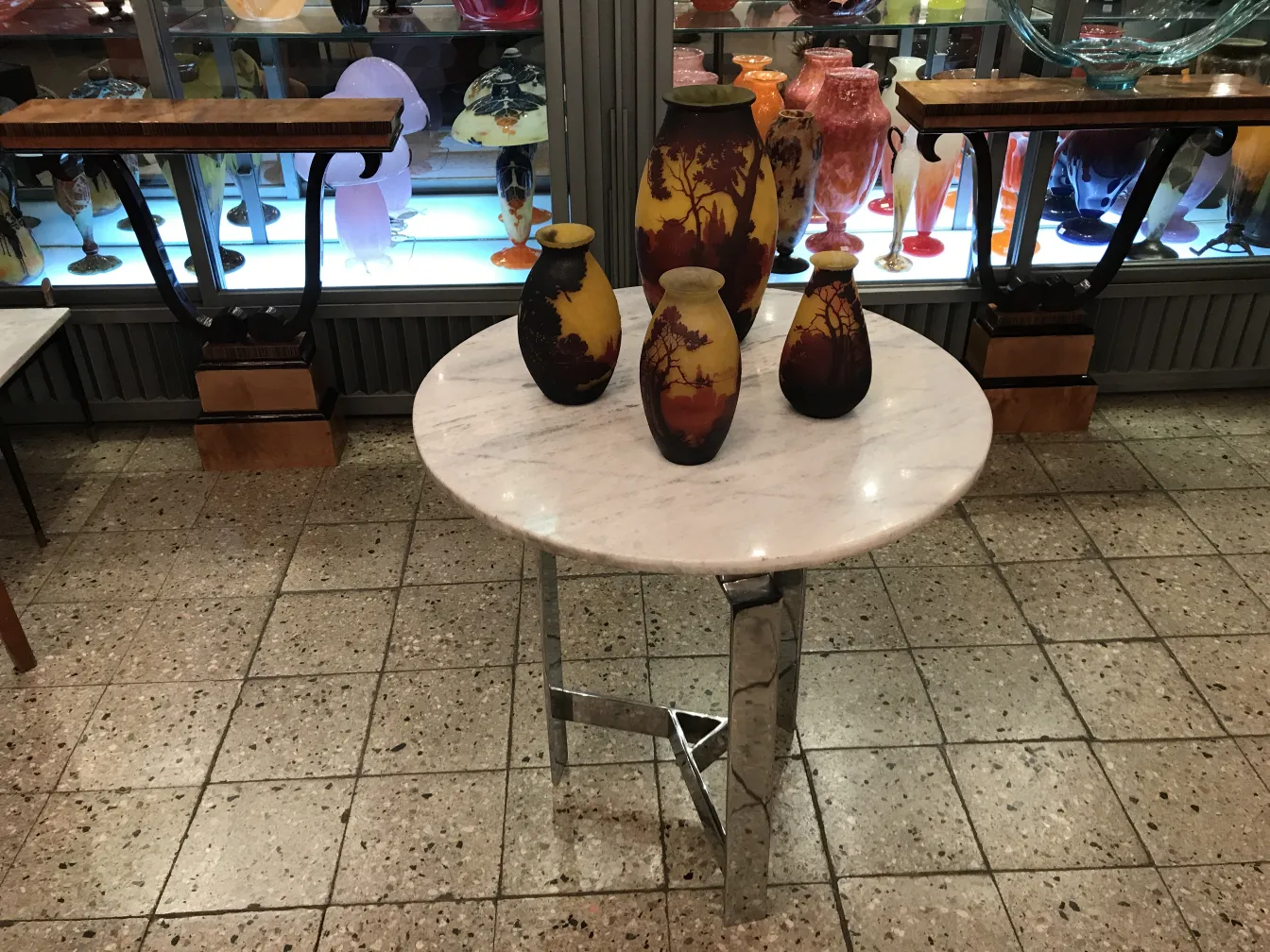 Vier dekorative Vasen in warmen Tönen auf einem Marmortisch.