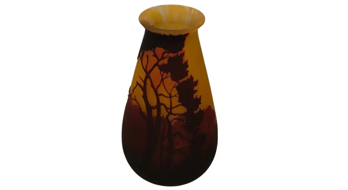 Antiguo vaso con detalles en tonos naranjas y marrones, árboles en silueta